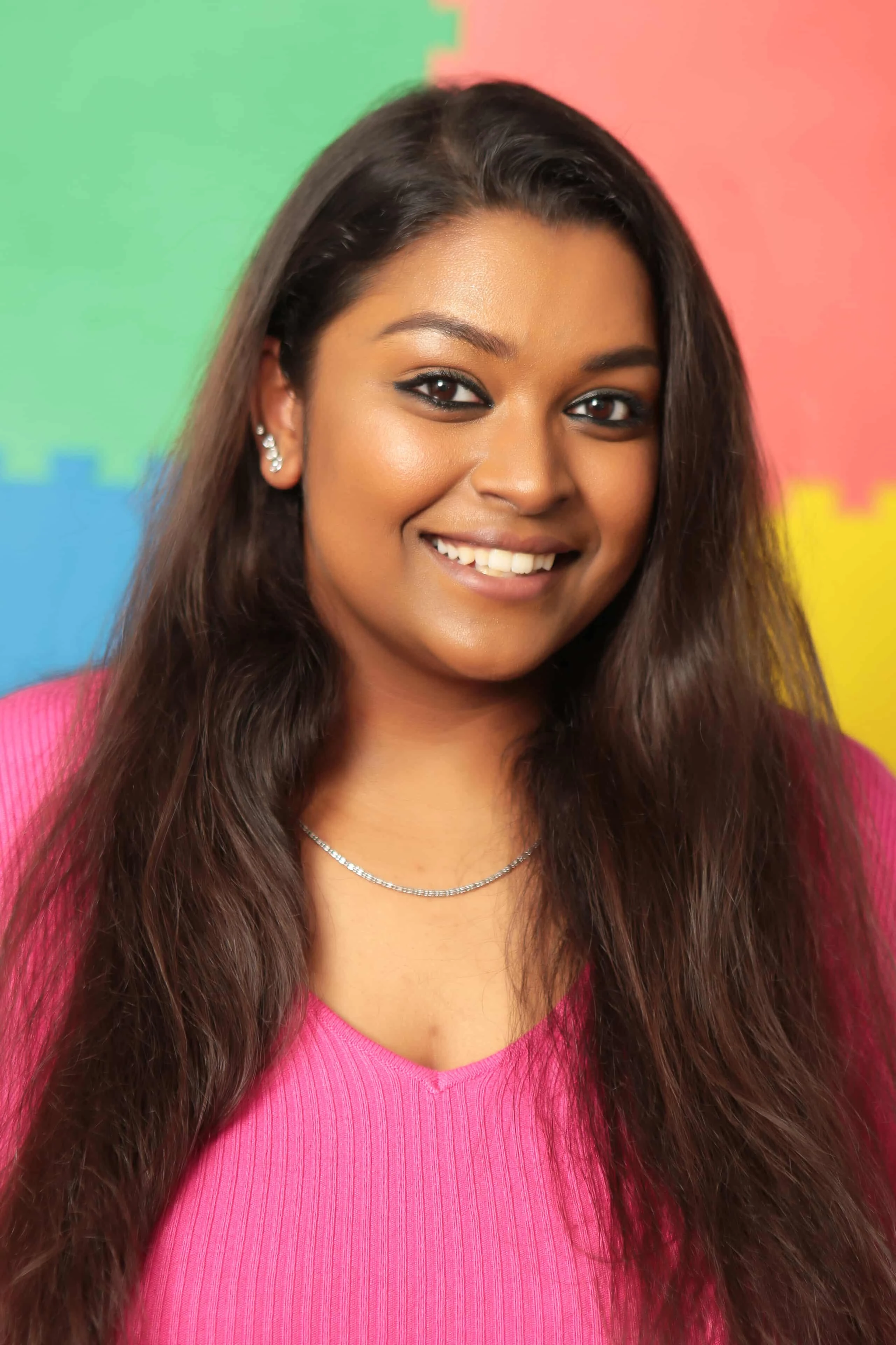 Smiling Asandra in front of a colorful background