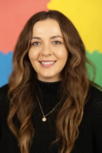 Smiling Aubrey against a colorful background